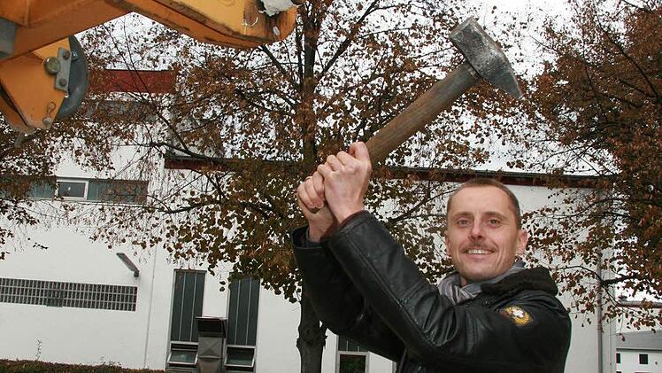 Mit dem Hammer müssen die riesigen Bolzen in schwindelnder Höhe eingeschlagen werden, demonstriert der technische Leiter und Prokurist der Firma Mühlherr, Jörg Eberlein am Boden.