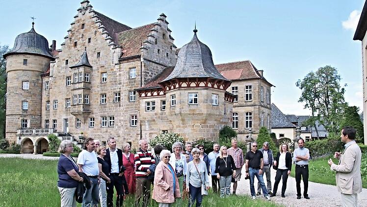 Hermann von Rotenhan (rechts) mit einer Gruppe im Schlossgarten und im Hintergrund das Schloss Eyrichshof.  Foto: Helmut Will