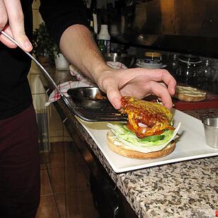 Ein Burger, der zum Teil aus Insekten besteht, wird am 24.02.2016 in Brüssel (Belgien) zubereitet. Foto: Simon Ribnitzky/dpa