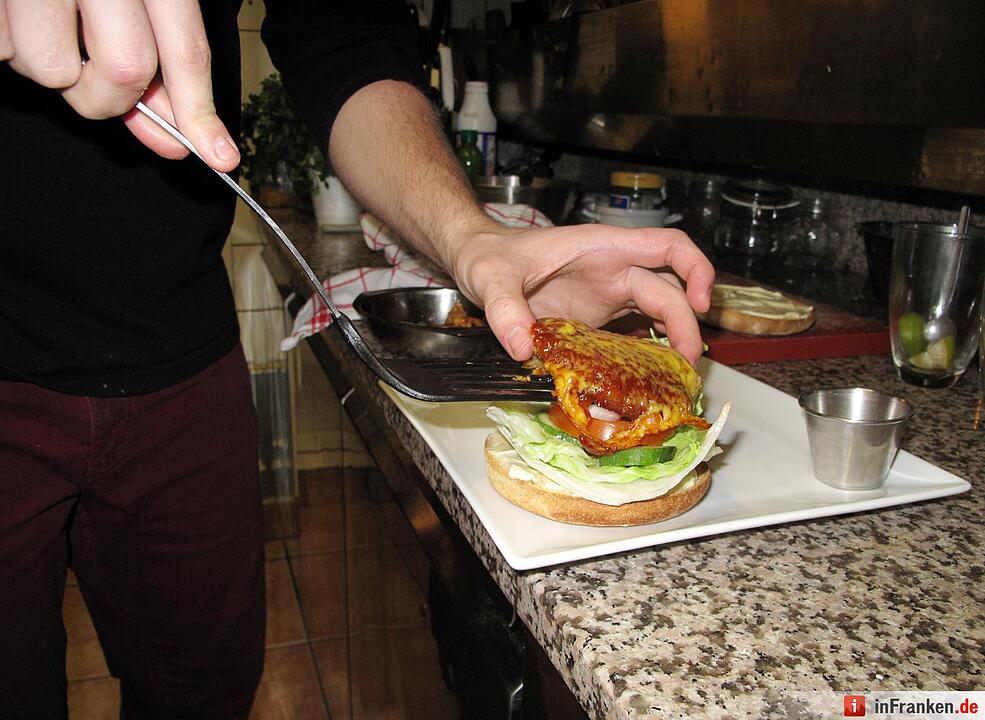 Ein Burger, der zum Teil aus Insekten besteht, wird am 24.02.2016 in Brüssel (Belgien) zubereitet. Foto: Simon Ribnitzky/dpa