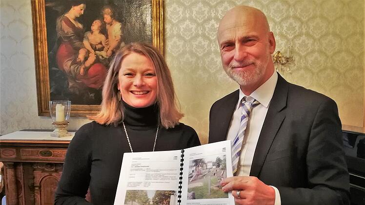 Oberbürgermeister Kay Blankenburg übergibt der Vorsitzenden des Familienbeirats, Kirsten Piening, das neue Spielplatzkonzept. Foto: Sigismund von Dobschütz