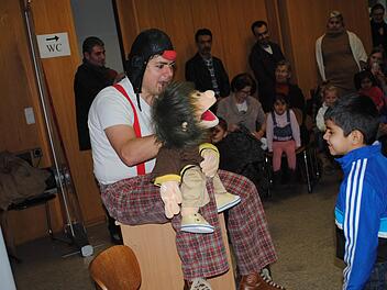 Clown Dirk Bayer versteht es, die Flüchtlingskinder aus der Reserve zu locken und zum Mitmachen zu animieren. Sprachprobleme spielen bei der Kommunikation mit seiner lustigen Handpuppe rasch keine Rolle mehr. So wird der Nachmittag im Asylbewerberheim in Ebern zu einem schönen Erlebnis für alle Beteiligten. Foto: Tanja Roppelt