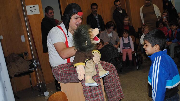 Clown Dirk Bayer versteht es, die Flüchtlingskinder aus der Reserve zu locken und zum Mitmachen zu animieren. Sprachprobleme spielen bei der Kommunikation mit seiner lustigen Handpuppe rasch keine Rolle mehr. So wird der Nachmittag im Asylbewerberheim in Ebern zu einem schönen Erlebnis für alle Beteiligten. Foto: Tanja Roppelt
