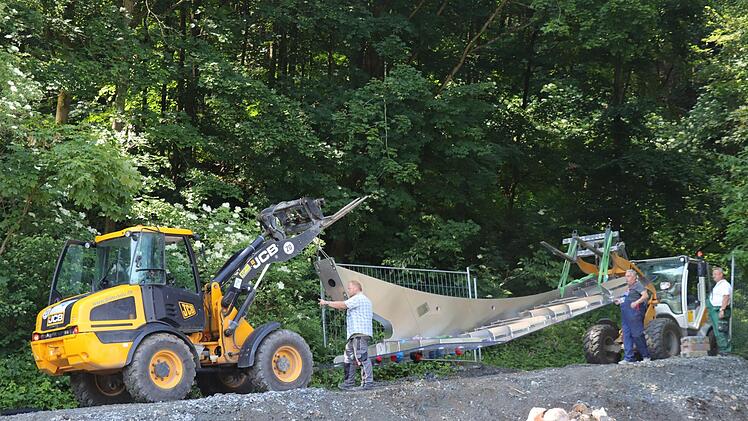 Zwei Radlader  transportieren die Kletterwand über die Baustraße ans neue Springerbecken.Foto: Katrin Geyer