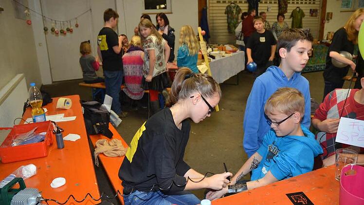 Die Tattoos von Luisa Kestel waren begehrt. Im Hintergrund Alexandra Förtsch und Ute Fischer-Petersohn (Eine Welt Laden) sowie Evi und Günther Scheler (Benin-Afrika-Produkte).