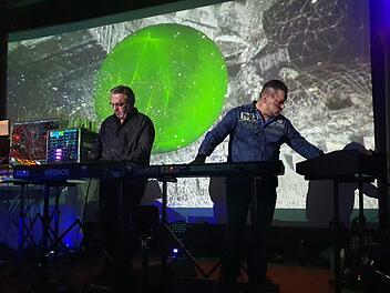 Kurt Adler und sein Sohn Dominik (von links) gaben einen Eindruck von dem bombastischen gewaltigen  Gepräge ihrer Tonwelten. Mit dem animierten Hintergrund schufen sie  eine bebende unwirkliche Szenerie. Eintauchen in die Elektronik.Brigitte Krause