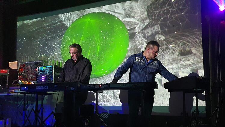 Kurt Adler und sein Sohn Dominik (von links) gaben einen Eindruck von dem bombastischen gewaltigen  Gepräge ihrer Tonwelten. Mit dem animierten Hintergrund schufen sie  eine bebende unwirkliche Szenerie. Eintauchen in die Elektronik.Brigitte Krause