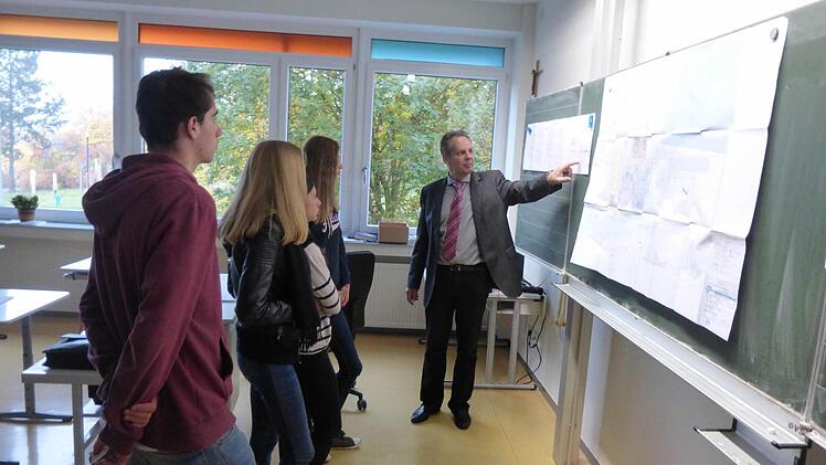Hans-Ulrich Hoßfeld vom Ingenieurbüro Hoßfeld & Fischer (Bad Kissingen) erläutert Schülern Pläne einer Kläranlage. Foto: Michael Kübert