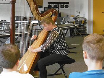 Musikstunde einmal anders: Maria Graf erklärt den Schülern der Realschule die Harfe. Foto: Regina Rinke