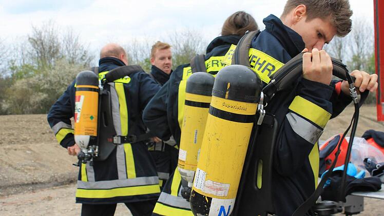 Die Feuerwehrleute machen sich für den Einsatz bereit.