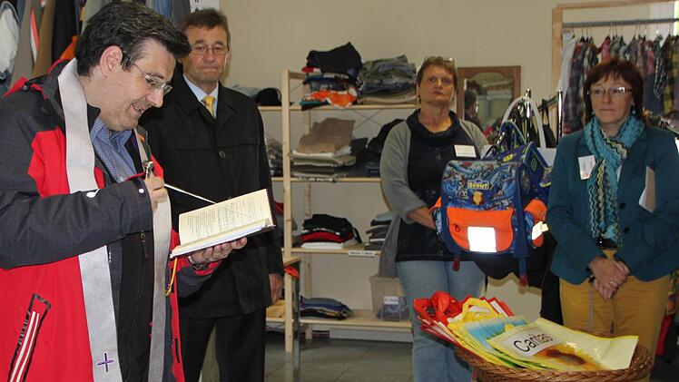 Dekan Michael Krammer (von links) liest ein Gebet, während Ludwig Sauer (Geschäftsführer des Caritasverbandes für den Landkreis Bad Kissingen), Erika Ankenbrand (Ehrenamtliche) und Helga Vierheilig (Fachdienst Gemeindecaritas) in den neu eingerichteten Räumen zuhören. Foto: Ulrike Müller