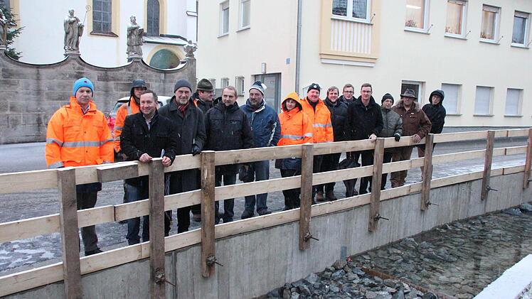 Die Teilnehmer des Schaufelfestes an der sanierten Ufermauer des Zeyernbachs. Das neue Geländer wird später angebracht. Foto: Friedwald Schedel