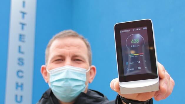 Kohlendioxid-Sensoren hat die Stadt l&auml;ngst f&uuml;r Grund- und Mittelschule angeschafft. Hier zeigt Hausmeister J&ouml;rg Schr&ouml;ter eines der Messger&auml;te. Bis zu einem Anteil von 800 Teilchen pro einer Million (ppm) steht die Ampel auf gr&uuml;n, &uuml;ber 1200 ppm muss gel&uuml;ftet werden. Offen ist noch, ob in beiden Schulen auch Luftfilter zum Einsatz kommen sollen.