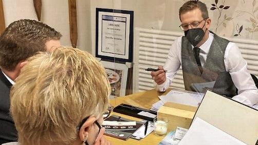 Trauergespräch unter erschwerten Bedingungen: Jochen Gleißner tröstet Angehörige hinter der Glasscheibe, mit Maske.