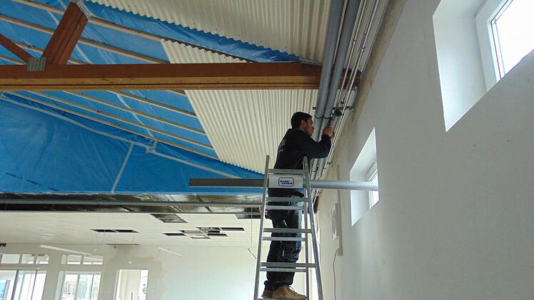 Jan Kretschmar montiert die Wandverkleidung. Foto: Petra Malbrich