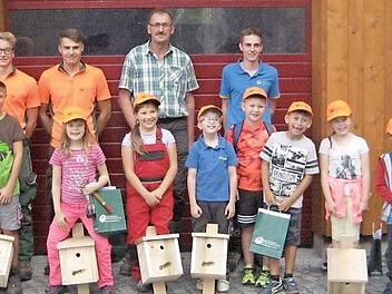 Die kleinen Nistkästenbauer mit (hinten, stehend, von links) den Auszubildenden beim Forstbetrieb Rothenkirchen, Randy Geyer, Max Mantel und Paul Schröder, Ausbilder Klaus Weiß sowie Azubi Julian Schubert, und ihren Nistkästen.  Foto: Karl-Heinz Hofmann