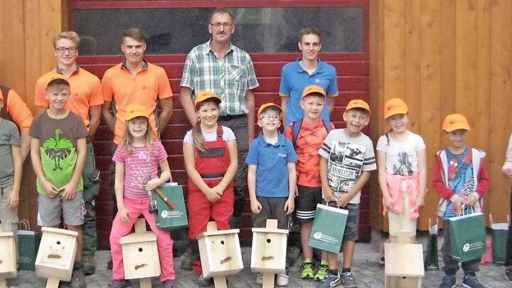 Die kleinen Nistkästenbauer mit (hinten, stehend, von links) den Auszubildenden beim Forstbetrieb Rothenkirchen, Randy Geyer, Max Mantel und Paul Schröder, Ausbilder Klaus Weiß sowie Azubi Julian Schubert, und ihren Nistkästen.  Foto: Karl-Heinz Hofmann