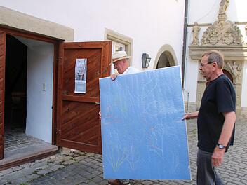 Die ersten Arbeiten sind schon da: Der Vorsitzender der Studiengenossen Münnerstadt, Paul Ziegler (links), trägt zusammen mit Rainer Nepita ein Werk des Künstlers in die Ausstellungsräume. Die Ausstellung wird am 7. Juli eröffnet. Foto:Thomas Malz