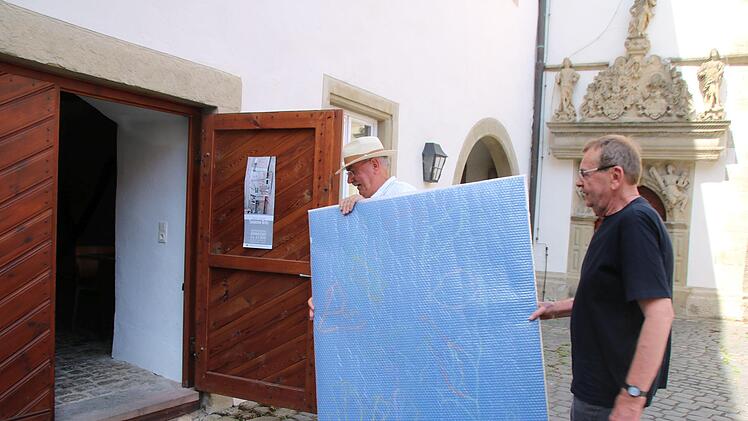 Die ersten Arbeiten sind schon da: Der Vorsitzender der Studiengenossen Münnerstadt, Paul Ziegler (links), trägt zusammen mit Rainer Nepita ein Werk des Künstlers in die Ausstellungsräume. Die Ausstellung wird am 7. Juli eröffnet. Foto:Thomas Malz
