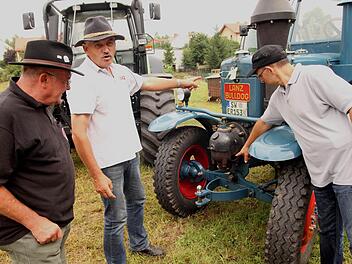 Ernst Rösch (Zweiter von links) erklärt die Funktionsweise des Glühkopfes an seinem Lanz 8506 aus dem Jahre 1942. Fotos: Günther Geiling