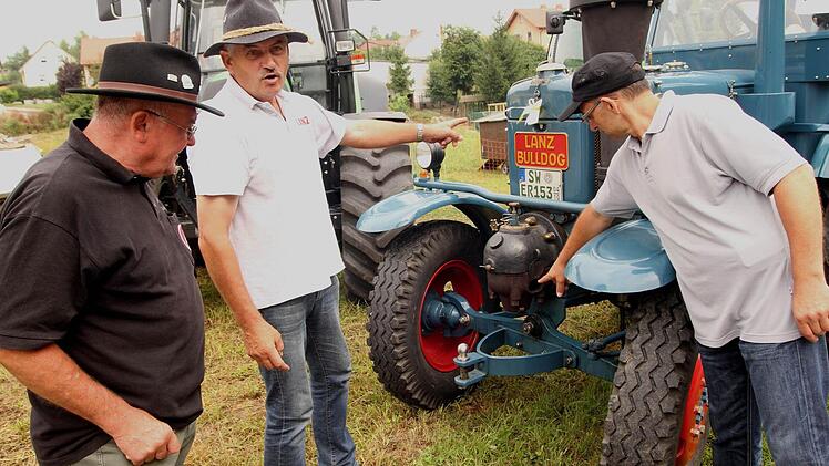 Ernst Rösch (Zweiter von links) erklärt die Funktionsweise des Glühkopfes an seinem Lanz 8506 aus dem Jahre 1942. Fotos: Günther Geiling