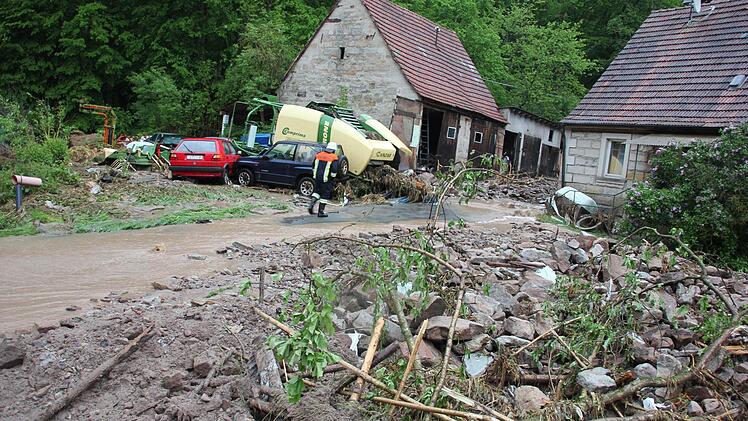 Bild der Verwüstung: die Paßmühle. Der Schaden liegt nach ersten Schätzungen der Polizei bei 150 000 Euro. Geröllbrocken hatten fünf Autos und eine Ballenpresse mitgerissen-