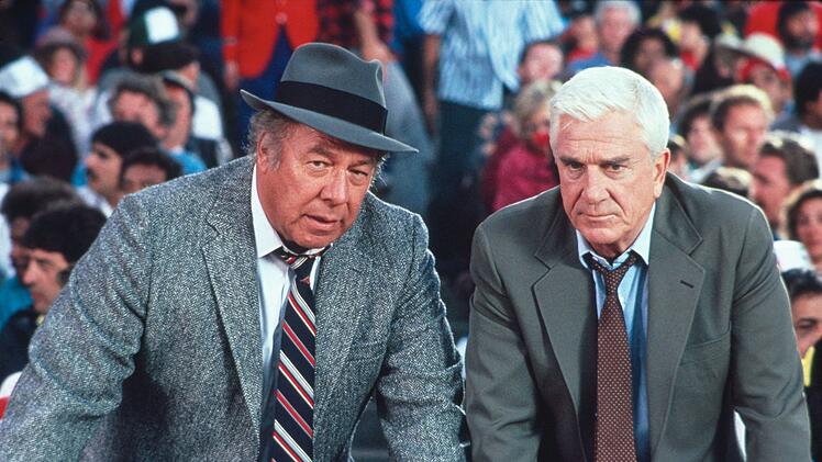 Ed Hocken (George Kennedy, links) und Frank Drebin (Leslie Nielsen) suchen im weiten Rund des Baseballstadions nach einem Attent&auml;ter.
