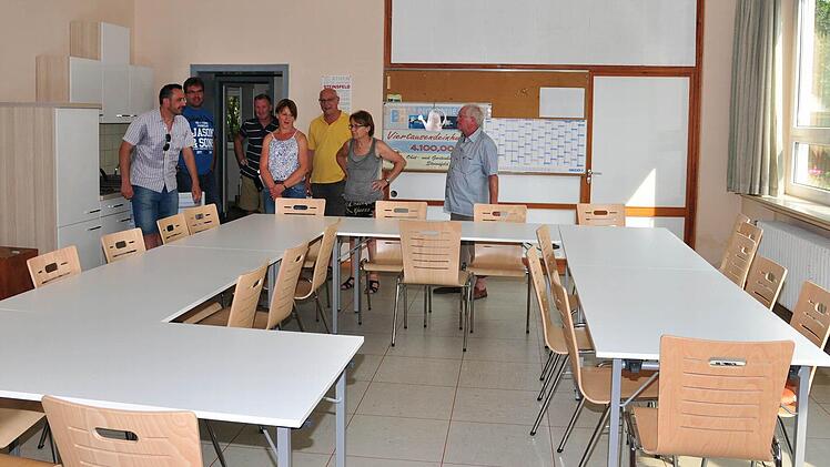 Für den großen Raum in der alten Schule in Steinsfeld wurden bereits neue Tische und Stühle erworben. Jetzt sollen noch die sanitären Anlagen komplett saniert werden. Bürgermeister Holger Baunacher (links im Bild) hofft dabei auf die Mitarbeit der Bevölkerung. Foto: Ulrike Langer
