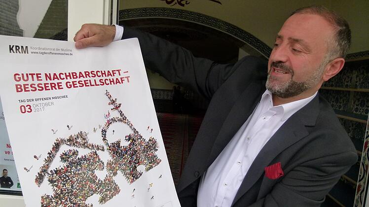 Auch die türkisch-islamische Gemeinde lädt zum Tag der offenenMoschee ein, wie Imam Coskun Sirri Mert es mit dem Plakat tut.