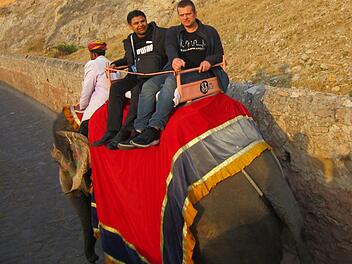 Pater Vijaya Raju Boddu und Mike Schmitt reiten auf einem Elefanten. Foto: Florian Stark