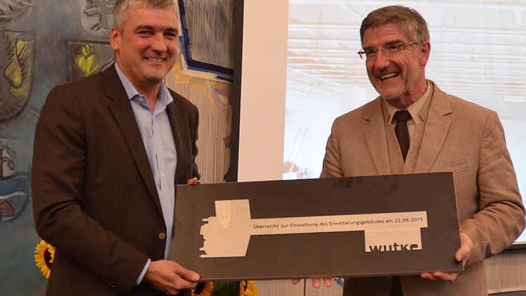 Architekt Christian Wutke (links) überreicht Landrat Michael Busch den symbolischen Schlüssel für den Erweiterungsbau.