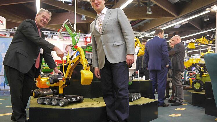 Bauen seit heuer auch Bagger aus Metall: "Rolly Toys", hier Geschäftsführer Frank Schneider (rechts) mit Neustadts Oberbürgermeister, Frank Rebhan. Foto: Berthold Köhler