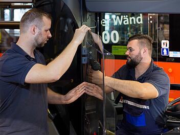 Stadtwerke-Mitarbeiter Sven Fischer (links) und Alexander Würl rüsten einen Stadtbus mit einer Hygienewand aus. Foto: Stadtwerke Bayreuth