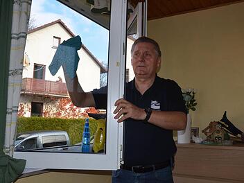 Kreisbrandrat Manfred Lorenz putzt die Fenster im Haus von Sabine Rudolph. Foto: Rainer Lutz