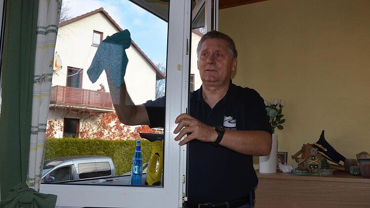 Kreisbrandrat Manfred Lorenz putzt die Fenster im Haus von Sabine Rudolph. Foto: Rainer Lutz