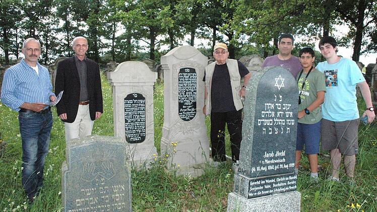 Zum jüdischen Friedhof in Ermershausen, wo seine Vorfahren begraben sind, zieht es Jakob Hecht (Mitte) immer wieder hin. Diesmal waren Steinmetz Andreas Vogt aus Ermershausen (von links), der die Gräber der Familie Hecht sanierte, Bürgermeister Wilhelm Schneider, Hechts Sohn Joel und die beiden Enkel Roei und Daniel dabei.  Foto: Schmidt