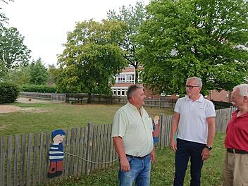 Georg Habermann, Ralf Olmesdahl und Josef Staudigel (von links) wollen sich nicht so schnell damit abfinden, dass das alte Aischer Schulhaus (im Hintergrund) abgerissen und auf dem Spielplatz (links) ein neuer Kindergarten gebaut werden soll.  Fotos: Andreas Dorsch