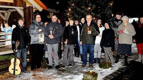 Vor der Krippe am Dorfplatz wurde das Friedenslicht von Bethlehem weitergegeben und in die Nacht getragen. Fotos: Günther Geiling