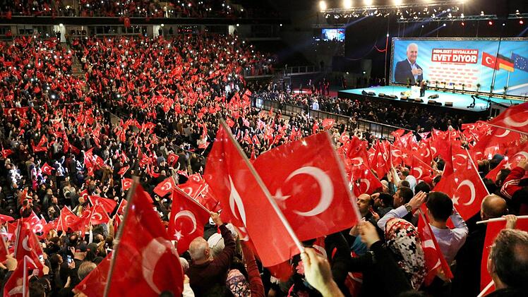 Teilnehmer bei einer Veranstaltung mit dem türkischen Ministerpräsidenten Yildirim halten am 18.02.2017 in Oberhausen (Nordrhein-Westfalen) türkische Fahnen in den Händen. Foto: Roland Weihrauch/dpa