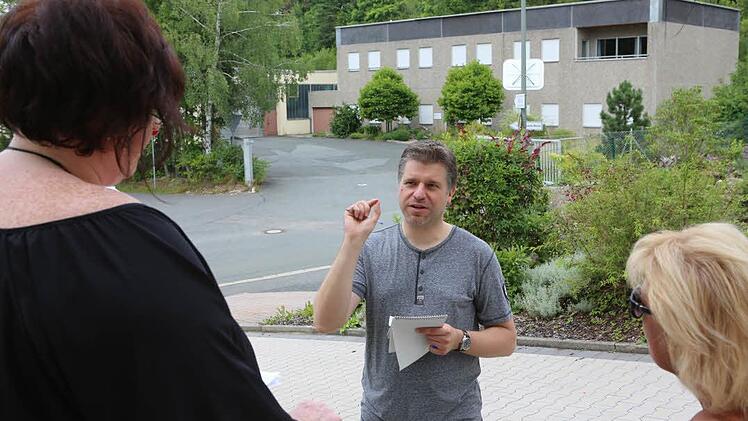 Reporter Matthias Litzlfelder im Gespräch mit Anwohnern: Die Schraubenfabrik im Hintergrund war ein Arbeitsplatz vor der Haustür. "Schade, dass so etwas zumacht. Wir haben sonst keine Industrie hier", sagen sie. Foto: Barbara Herbst