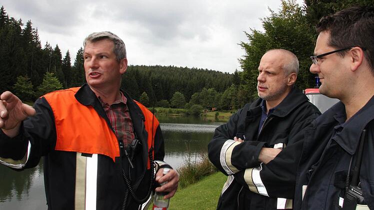 Übungsleiter Christian Schulz am Einsatzort Ölschnitzsee im Gespräch zwei Feuerwehrmännern aus Kronach. Fotos: Corinna Igler
