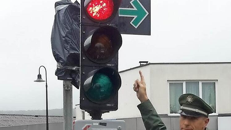 Ein Grüner Pfeil erlaubt unter bestimmten Voraussetzungen auch bei roter Ampel das Abbiegen. Polizeihauptkommissar Reinhard Kuklinski weist auf das neue Zeichen hin.  Foto: Rolf Pralle