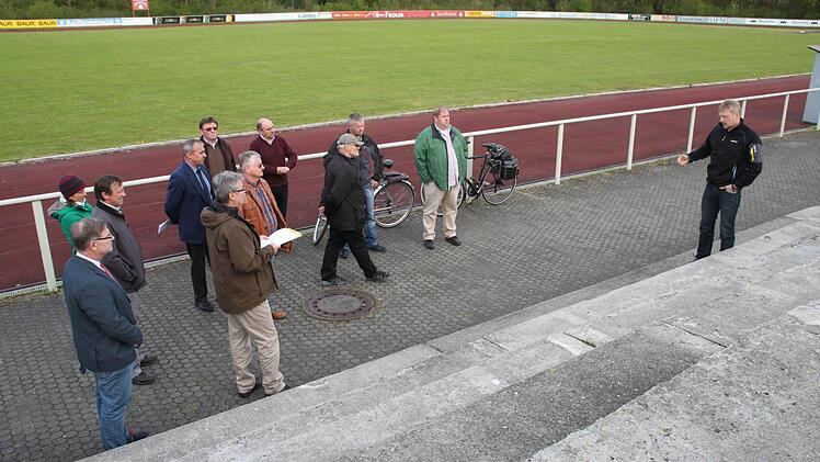 Die Tribüne beim Hauptspielfeld im Schul- und Sportzentrum in Röhrig soll abgerissen und durch eine neue Standmöglichkeit für die Zuschauer ersetzt werden. Darauf verständigte sich der Bauausschuss. Bautechniker Armin Freitag (rechts) erläuterte den Mitgliedern mögliche Varianten. Foto: Stephan Stöckel.