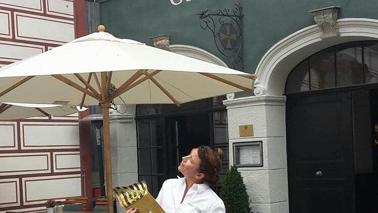 Julia Humpert, Mitarbeiterin im "Goldenen Kreuz", schaut nach oben zum Dach des Stadthauses - von dort kam die Metall-Fahne geflogen. Foto: Coburger Tageblatt