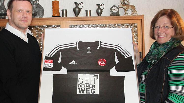 Club-Aufsichtsratsmitglied Chris Ehrenberg hat Ursula Eisenhut das Trikot von  Timo  Gebhardt überreicht. Am dritten  Spieltag  trugen alle  Bundesligaspieler den Schriftzug der Integrationskampagne "Geh Deinen Weg" auf der Brust. Foto: Alexander Hartmann