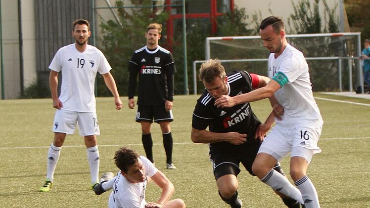 Der Sander Kapitän Thorsten Schlereth (Zweiter von rechts) im Duell mit Gästekapitän Sebastian Schäferlein (rechts)