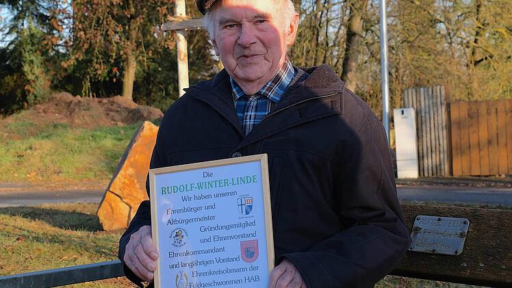 Ein Volltreffer war das Geburtstagsgeschenk von Freunden für Rudolf Winter. Voller Freude präsentiert der Altbürgermeister die Urkunde vor der neu gepflanzten Rudolf-Winter-Linde. Foto: Gerd Schaar