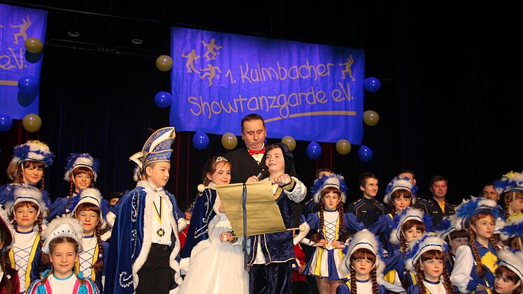 Hofmarschall Denis Hartmann (mit Mikrofon) stellte das Kinderprinzenpaar Eva I. (Tröglen) und Jonas I. (Ruppert) vor. Matthias Foerster (stehend, hinten) führte durch das Programm. Foto: Stephan Stöckel