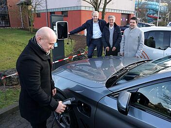 Dietmar Klenk, technischer Leiter der Herzo-Werke, "betankt" den Dienst-BMW des Bürgermeisters, beobachtet von German Hacker, Jürgen Bauer und Patrick Geiger, dem Leiter der Herzo-Bäder- und Verkehrs-GmbH (v. l.).     Foto: Richard Sänger