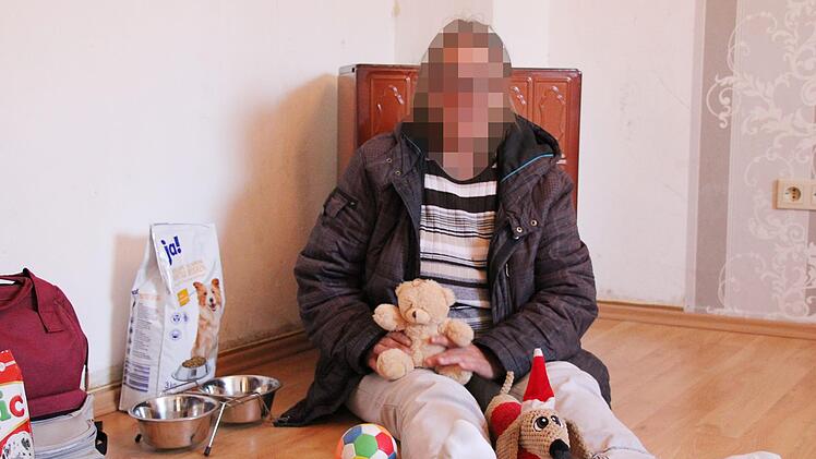 Rosalinde Eckart (Name geändert) sitzt mit dem Spielzeug ihrer Hündin Lotte auf dem Fußboden ihres Schlafzimmers. Sie hofft jeden Tag, dass sie das Tier wiederbekommt. Foto: Ulrike Müller